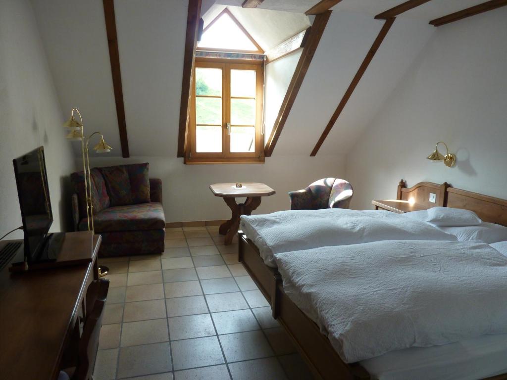 een slaapkamer met een bed, een tafel en een raam bij Gasthof Löwen in Wisen
