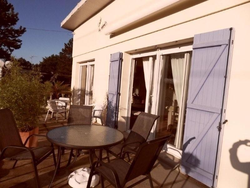 un patio con mesa y sillas en un porche en gite a st germain sur ay, en Bretteville-sur-Ay