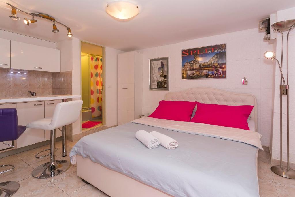 a bedroom with a large white bed with red pillows at Studio Varos in Split