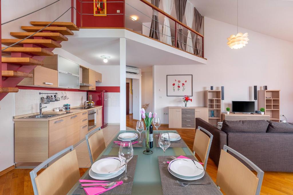 a dining room and living room with a table and chairs at Deluxe Apartment Marina with a private parking in Rijeka