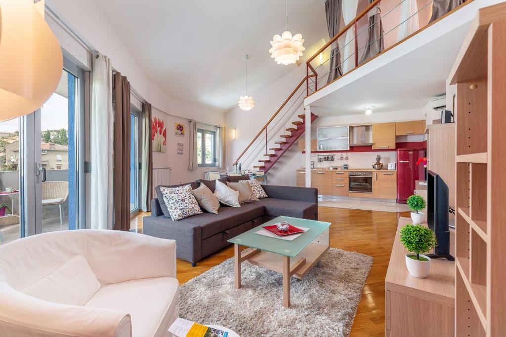 a living room with a couch and a table at Deluxe Apartment Marina with a private parking in Rijeka