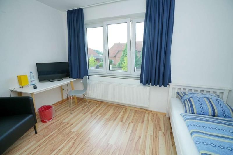 een slaapkamer met een bed, een bureau en een raam bij Lindenzimmer Stöcken in Oetzen
