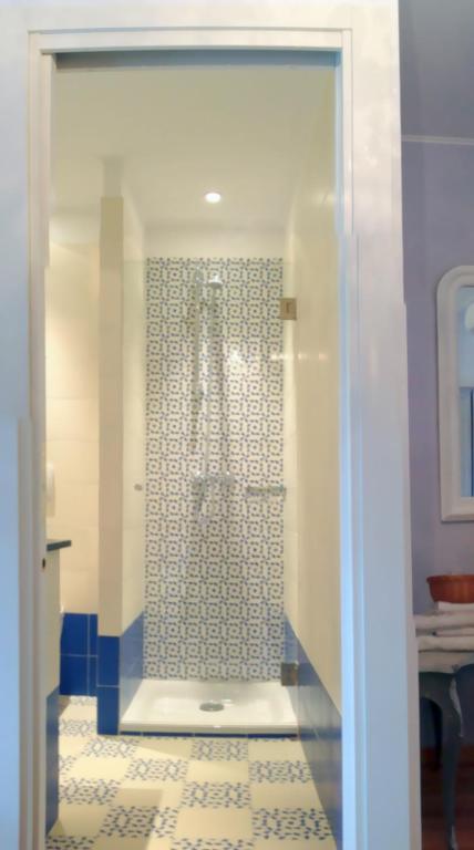 a bathroom with a shower with a tiled floor at Hotel La Regence in Villefranche-sur-Mer