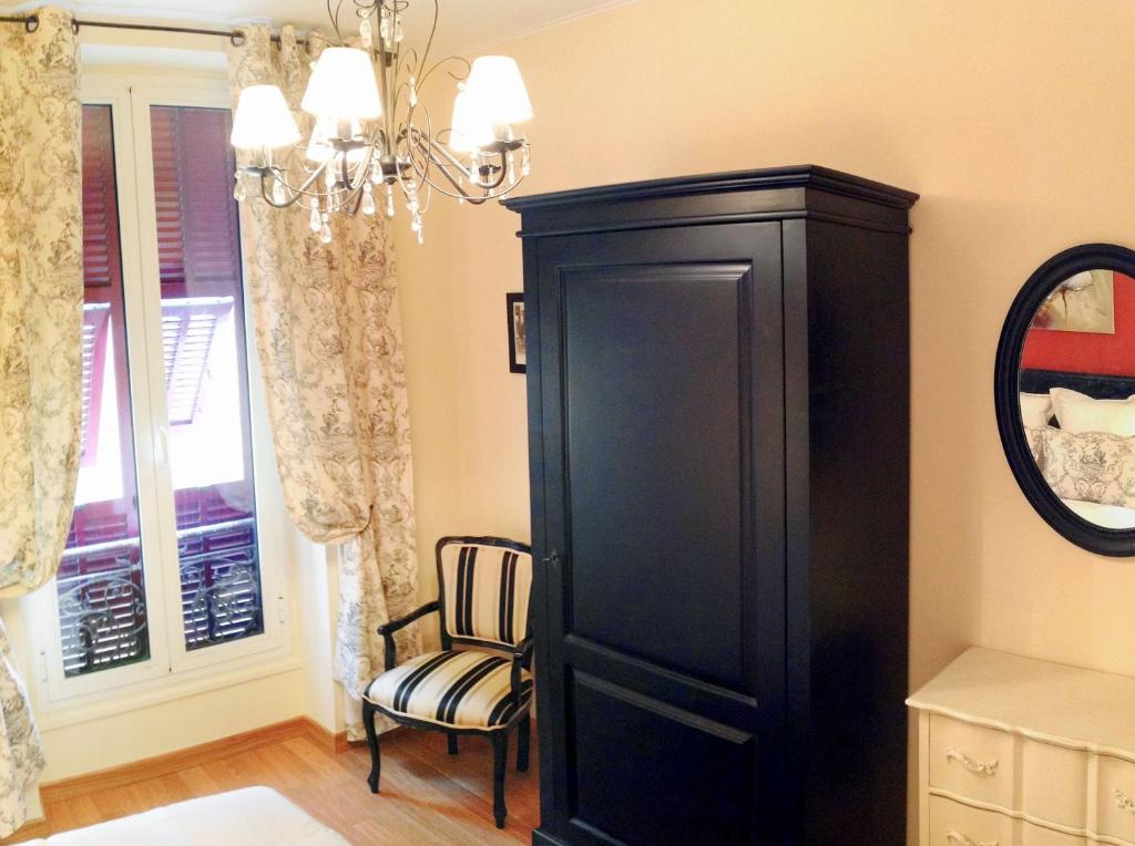 a large black cabinet in a room with a chair at Hotel La Regence in Villefranche-sur-Mer