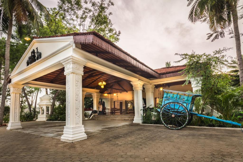 a large white house with a cart in front of it at Mantra Koodam Kumbakonam-CGH Earth in Kumbakonam