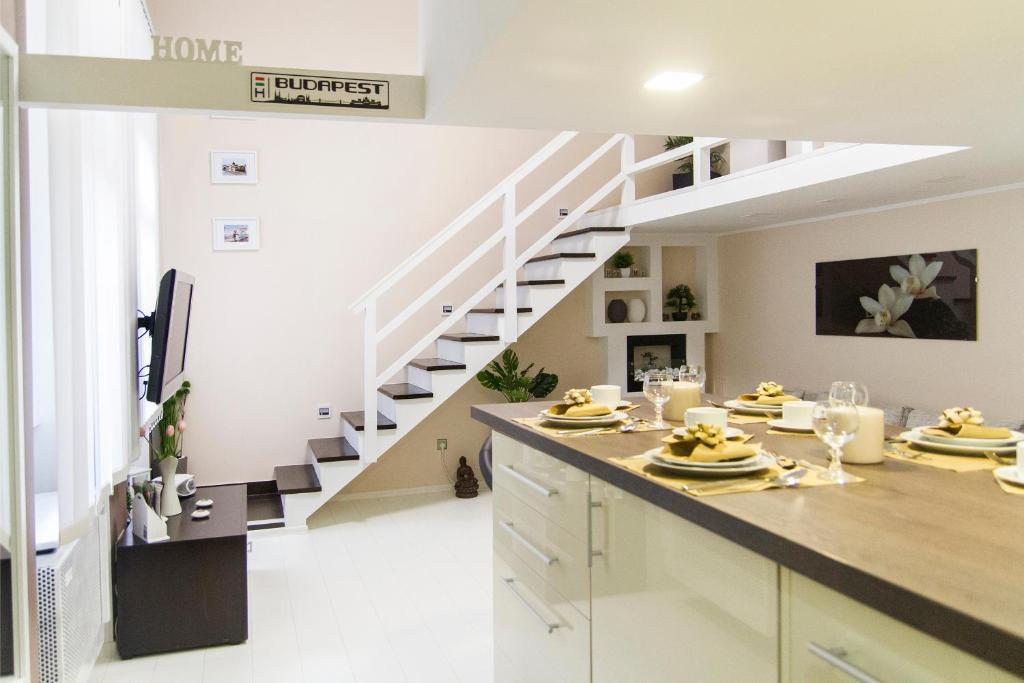 een keuken met witte kasten en een trap bij R&R Apartment Rákóczi in Boedapest