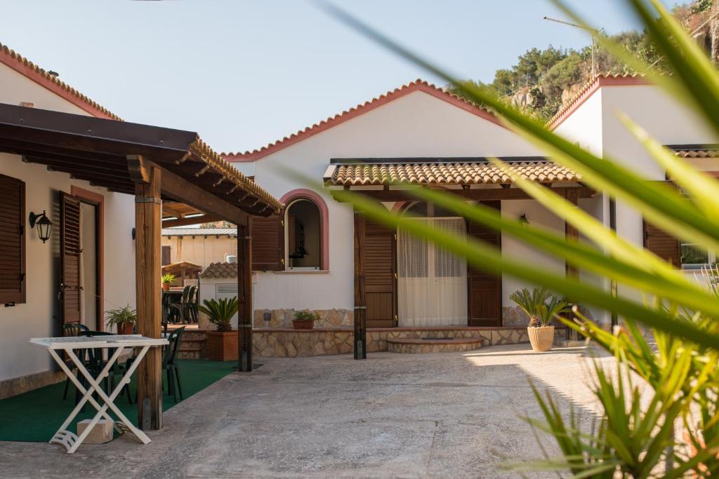 ein Haus mit einer Terrasse mit einem Tisch davor in der Unterkunft Baglio Scurati in Custonaci