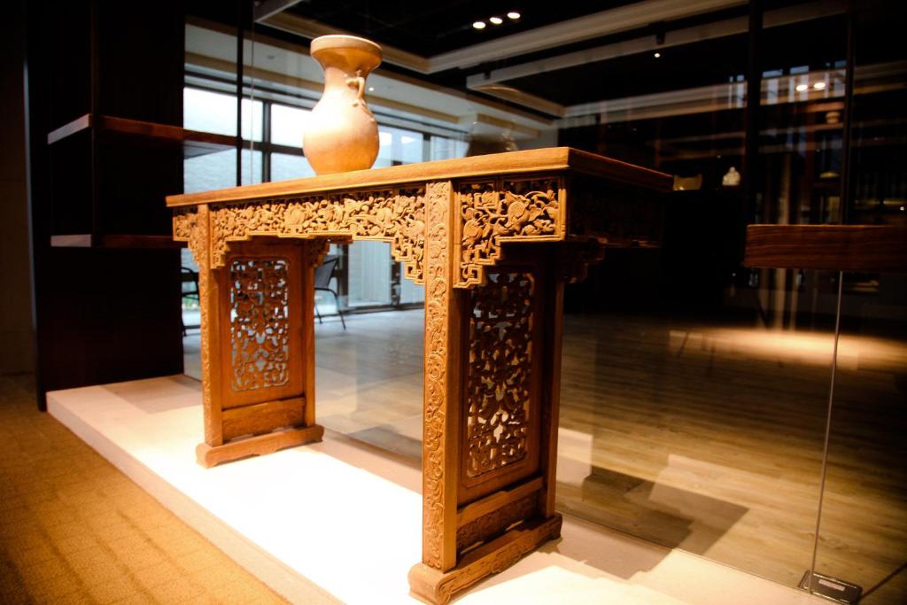 a wooden table with a vase on top of it at Micasa Hotel in Taichung