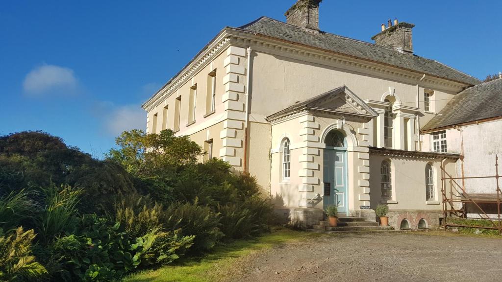 a large white building with a large door on it at Kelly House Country B&B in Lifton