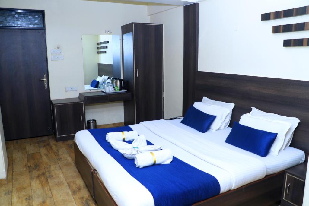 a large bed with blue and white towels on it at Hotel Alka Residency in Thane