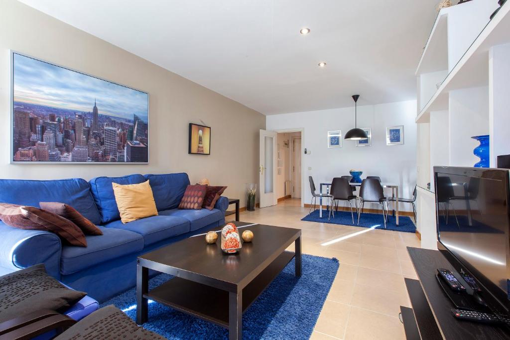 ein Wohnzimmer mit einem blauen Sofa und einem Tisch in der Unterkunft ARGANZUELA in Madrid