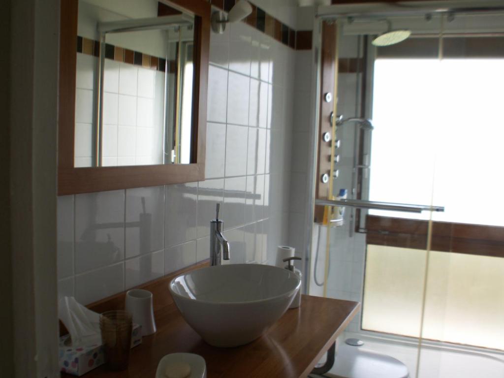 baño con lavabo y ventana en chambre normande en Courseulles-sur-Mer