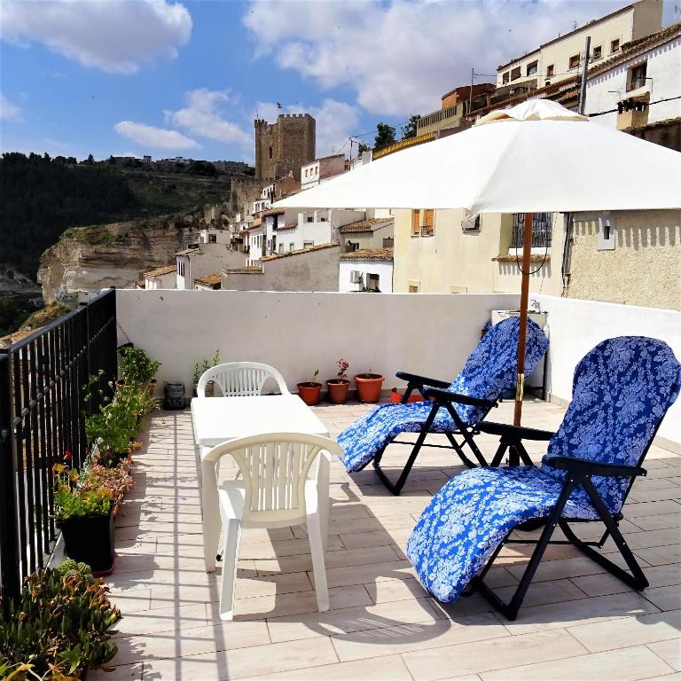 a patio with two chairs and an umbrella at Alojamiento Buena Vista in Alcalá del Júcar