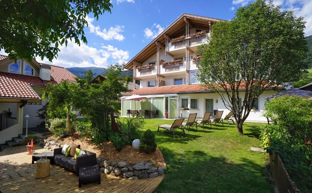 a building with a yard with chairs in front of it at Residence Walder in Falzes