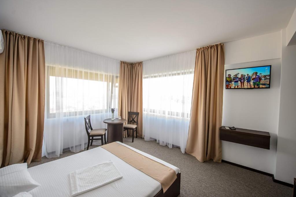 um quarto de hotel com uma cama, uma mesa e cadeiras em Casa lui Matei em Băltenii de Sus