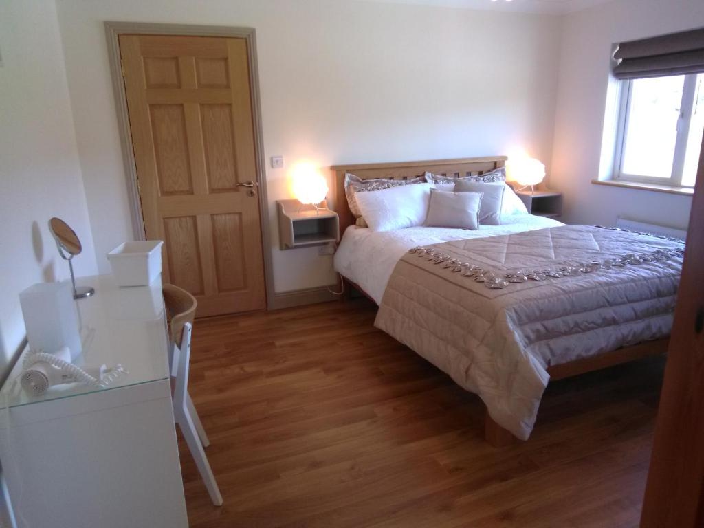 a bedroom with a bed and a window and two lamps at Burren Rock Farmhouse B&B in Turlough