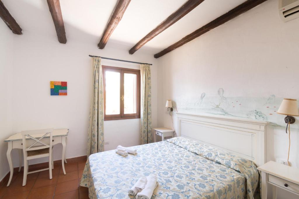 a bedroom with a bed and a table and a window at White Sand Residence in Murta Maria