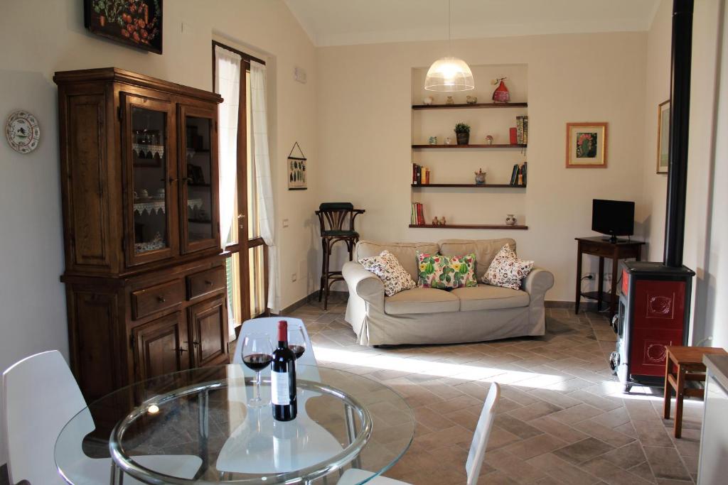 a living room with a couch and a glass table at Le Case in Bevagna