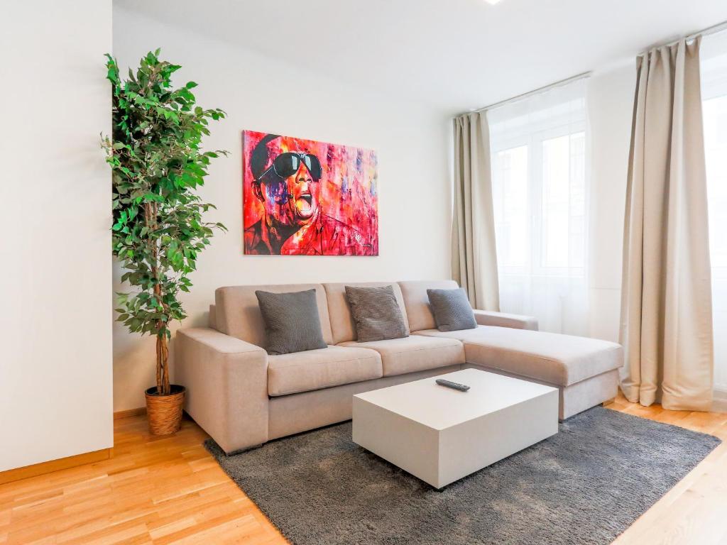 ein Wohnzimmer mit einem Sofa und einem Tisch in der Unterkunft SKY9 Apartments Margareten in Wien