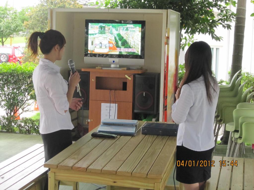 two women standing in front of a table playing a video game at Spring Fountain Hotel in Jiaoxi