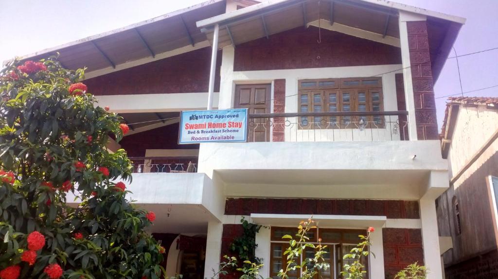 una casa con un cartel delante de ella en SWAMI home stay panhala, en Panhāla