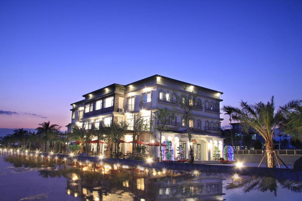 a large house with christmas lights on the water at Spring Fountain Hotel in Jiaoxi