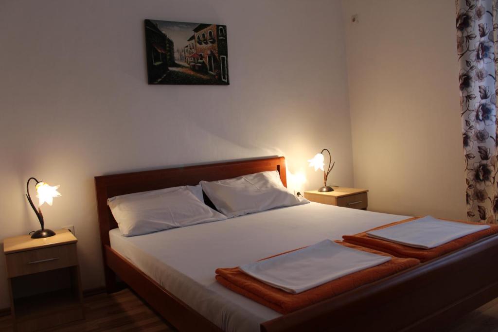 a bedroom with a bed with two lamps on both sides at Apartman Bo&scaron;ković in Budva