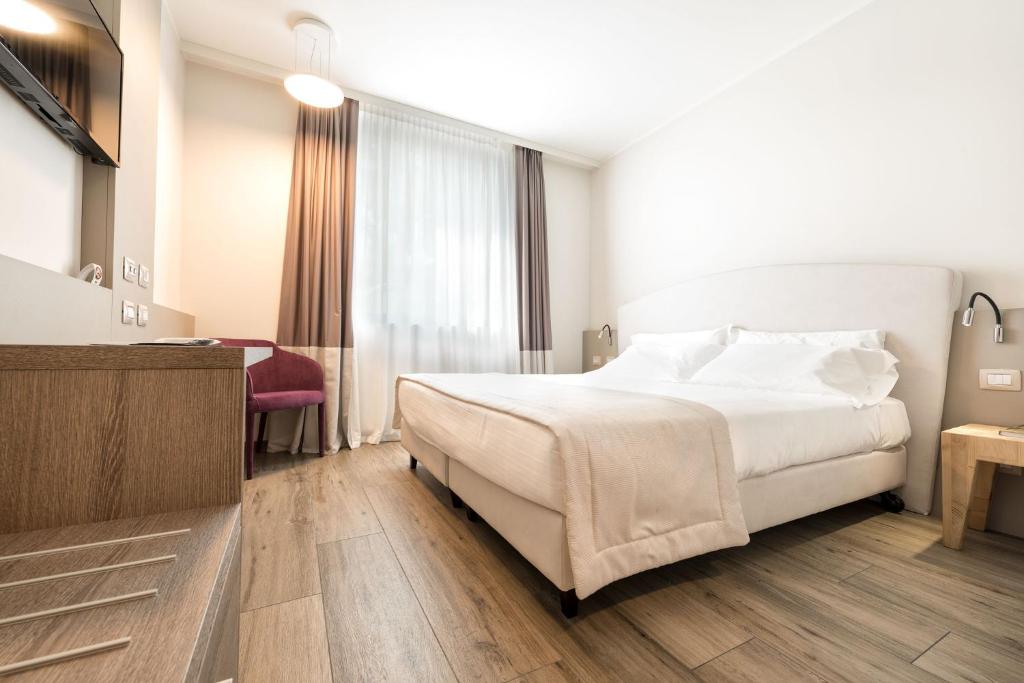 Postel nebo postele na pokoji v ubytování DB Hotel Verona Airport Congress & Spa