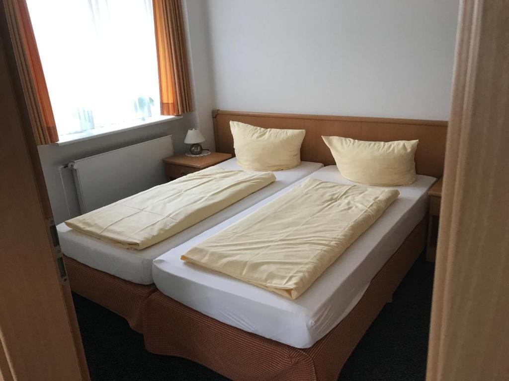 two twin beds in a room with a window at Arp's Gasthof in Schönkirchen