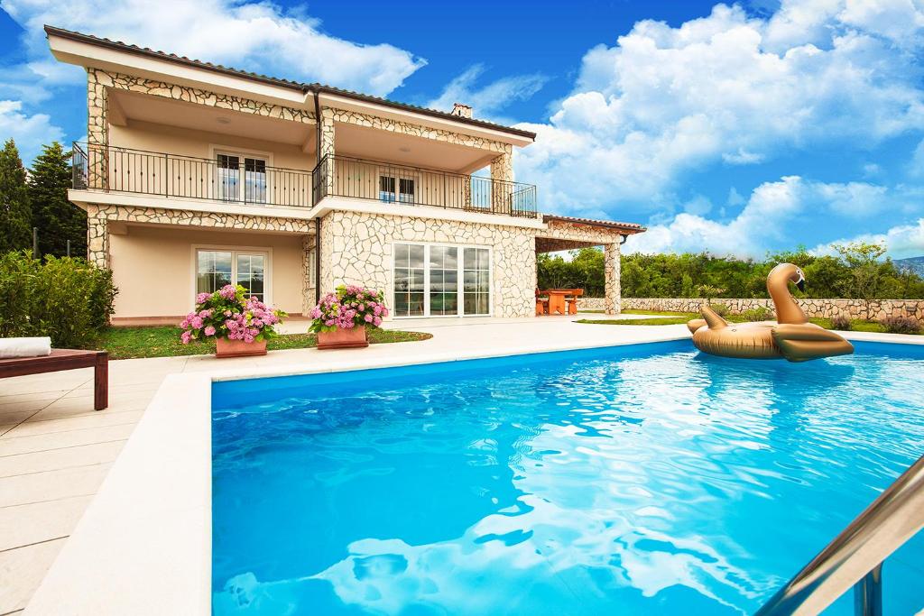 a villa with a swimming pool in front of a house at Villa Dora in Sužan