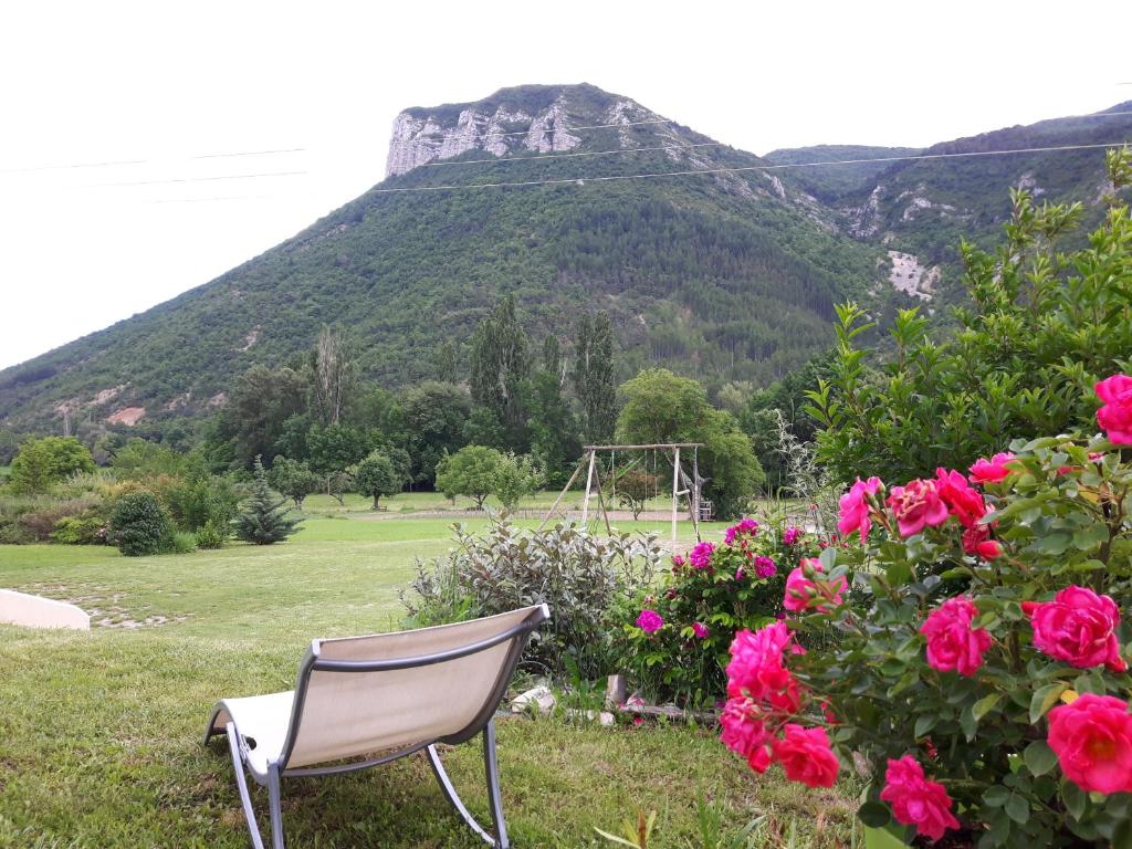 een stoel in een tuin met een berg op de achtergrond bij la petite maison 05 in Trescléoux
