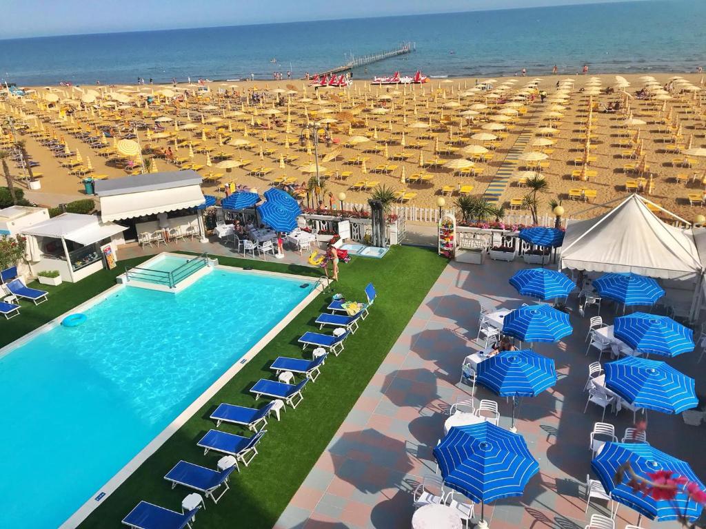 uma vista sobre uma praia com uma piscina e guarda-sóis em Hotel Marina em Lido di Jesolo