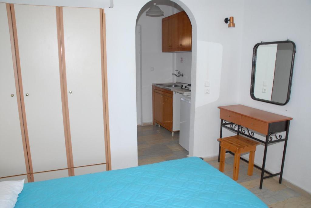 a bedroom with a bed and a desk and a mirror at Apollo in Kavos