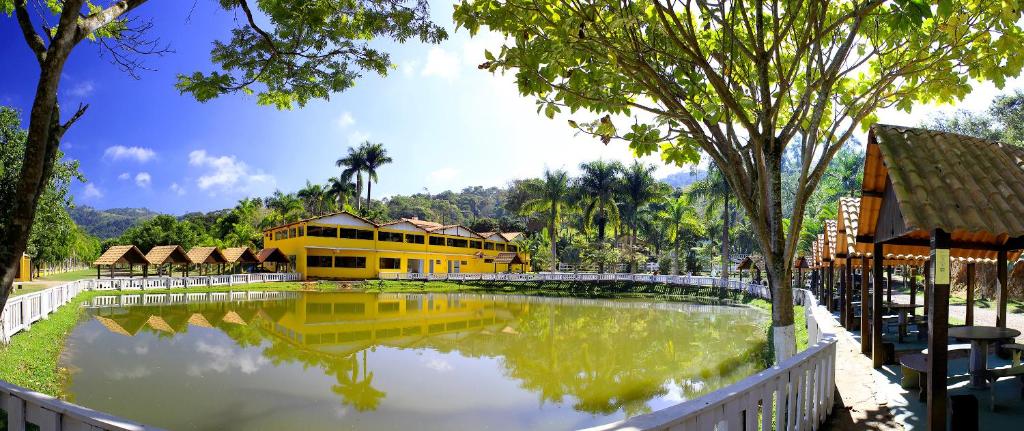 una grande piscina d'acqua di fronte a un edificio giallo di Pousada carvalho a Conselheiro Lafaiete