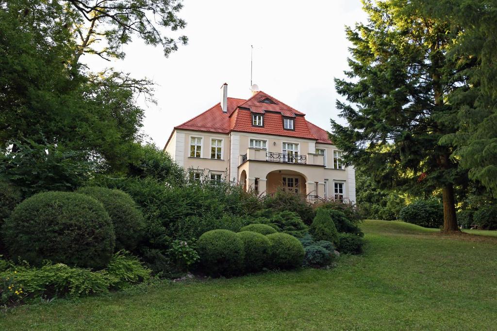 ein großes weißes Haus mit rotem Dach in der Unterkunft Dwór Bieland in Elblag