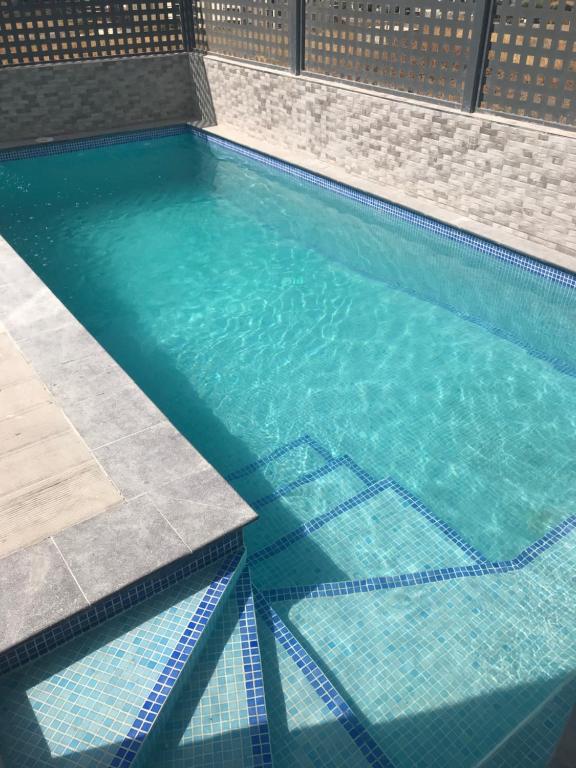トレ・デル・マールにあるvilla moderna con piscina privada, jardín y vista al Marの建物内の青い水のスイミングプール