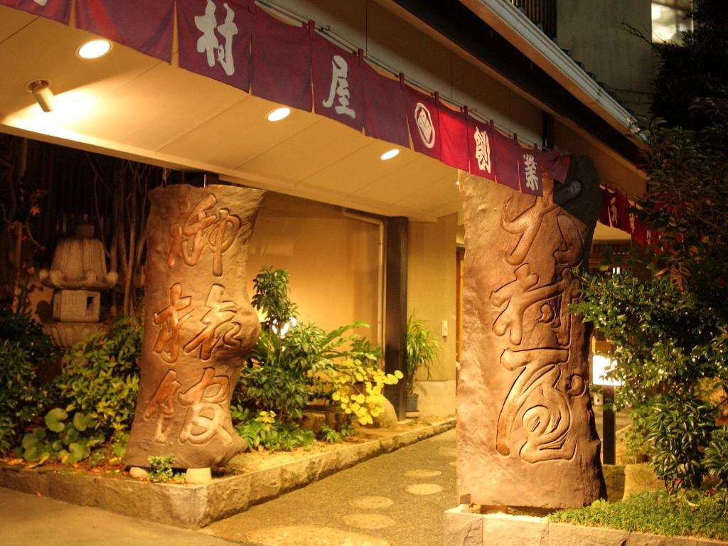 a store front with two wooden pillars in front of it at Ryokan Oomuraya in Ureshino