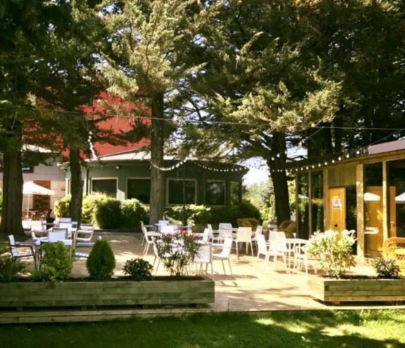 eine Terrasse mit weißen Stühlen und Tischen vor einem Haus in der Unterkunft Hotel Restaurante El Valles 4 ESTRELLAS in Briviesca