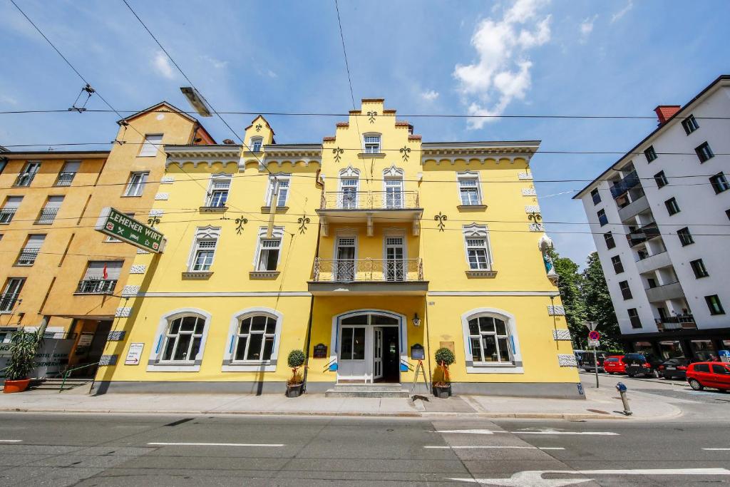 żółty budynek na rogu ulicy w obiekcie Hotel Lehenerhof w mieście Salzburg