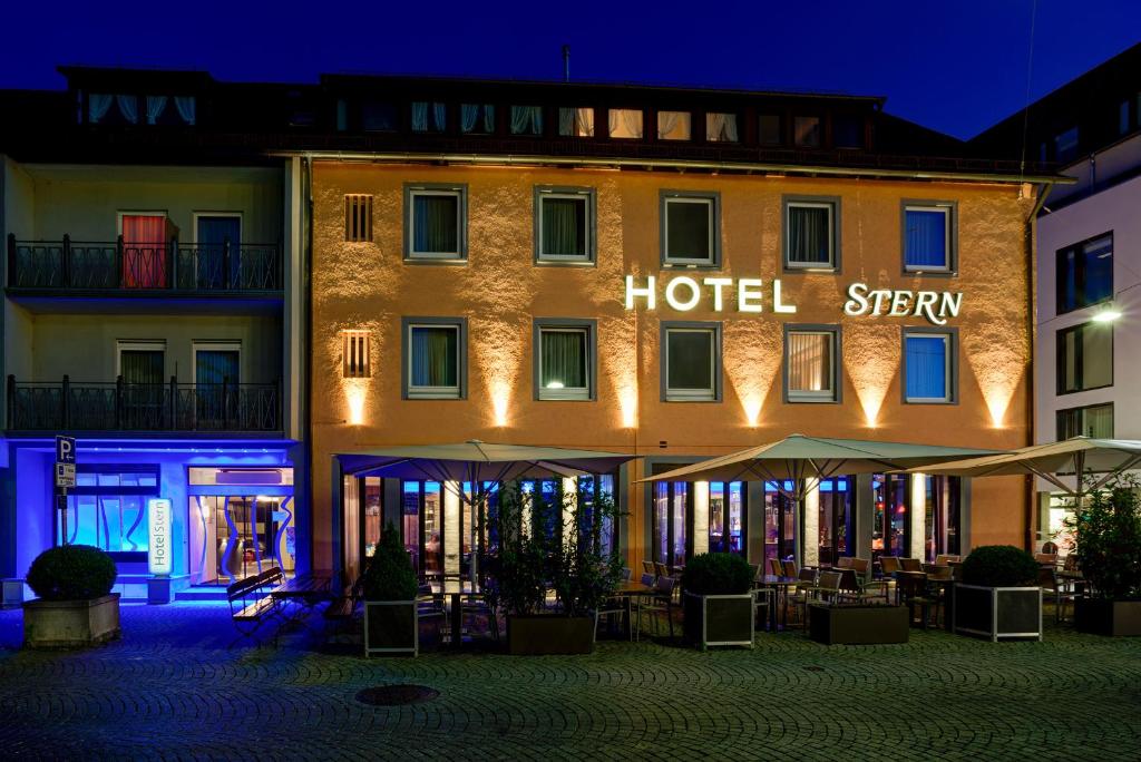 a hotel with tables and umbrellas at night at Centro Hotel Stern in Ulm