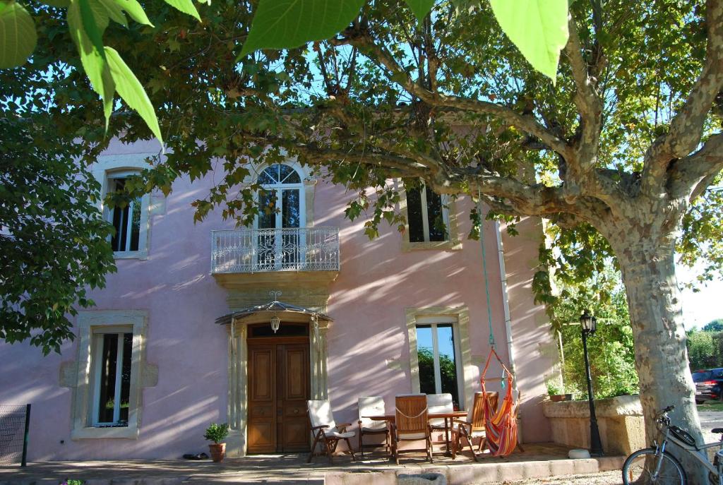 ein weißes Gebäude mit einem Baum davor in der Unterkunft Le Mas Richard in Générac