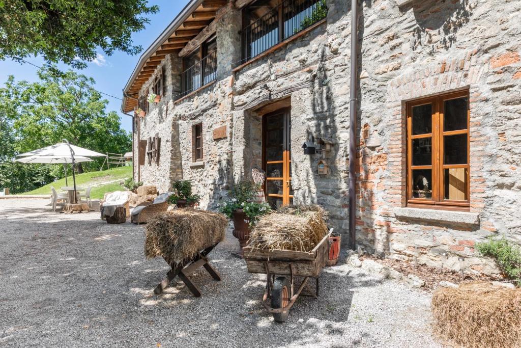 コモにあるAgriturismo Cascina Mirandolaの外に干し草の保釈がある石造りの建物