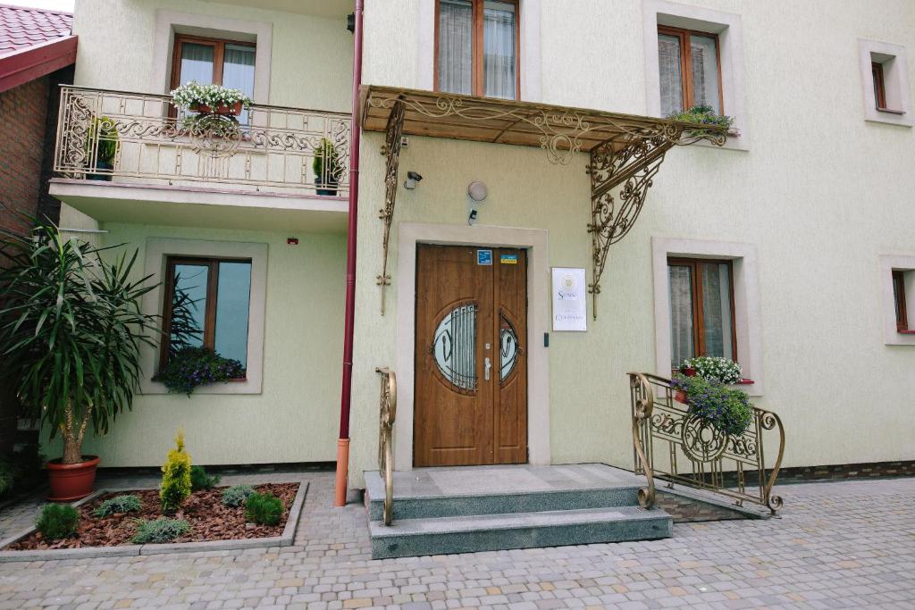 een gebouw met een houten deur en trap voor de deur bij Sunny Hotel in Lviv