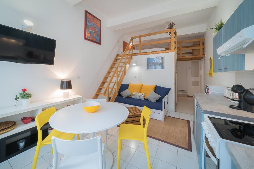 Il comprend une petite cuisine et un salon avec une table et des chaises. dans l'établissement Yellow Submarine, à Montpellier