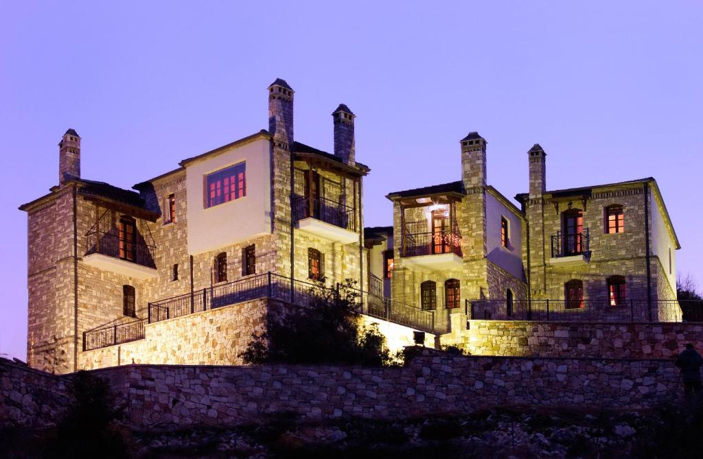 un ancien bâtiment en pierre avec trois cheminées au-dessus dans l'établissement Aiolides Traditional Homes, à Asprangeloi