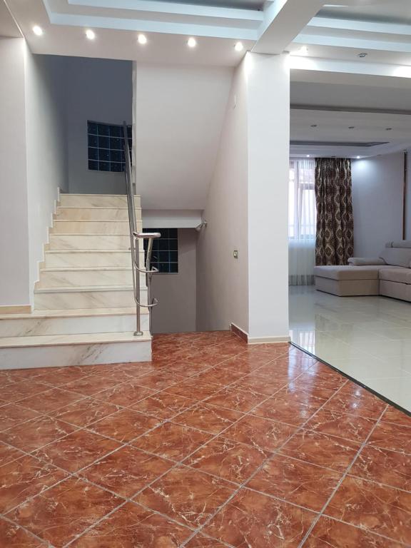 una stanza vuota con una scala e un pavimento piastrellato di Vila Nicol a Constanţa