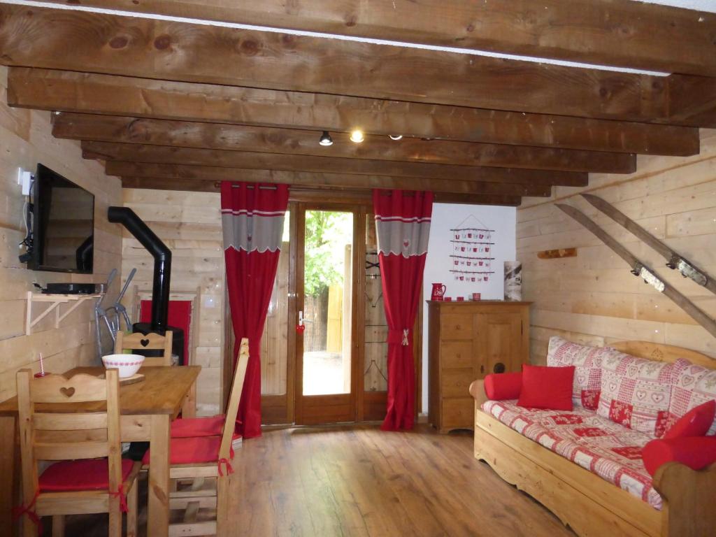 a living room with red drapes and a couch at CAP DES NEIGES 1 in Barcelonnette