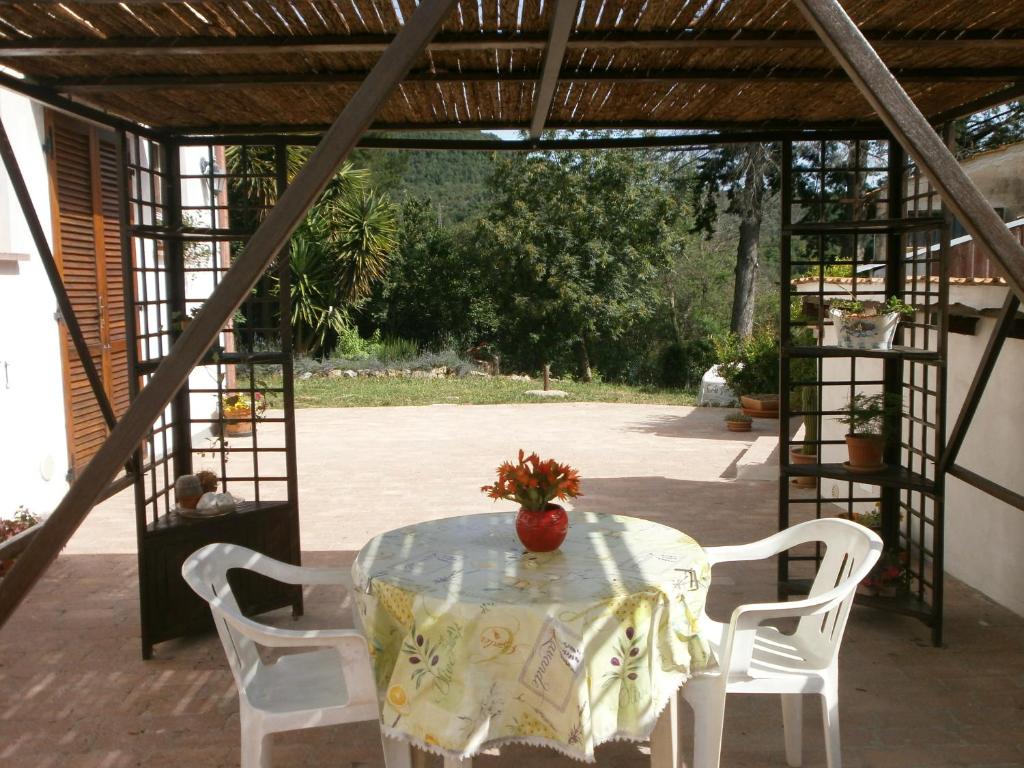 スヴェレートにあるMonolocale di Meoの白い椅子と花瓶が置かれたテーブル