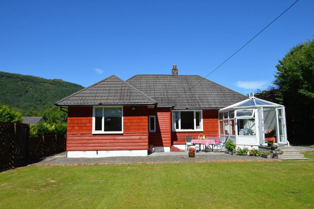 uma pequena casa vermelha com um gazebo em Cedar Cottage em Dunoon