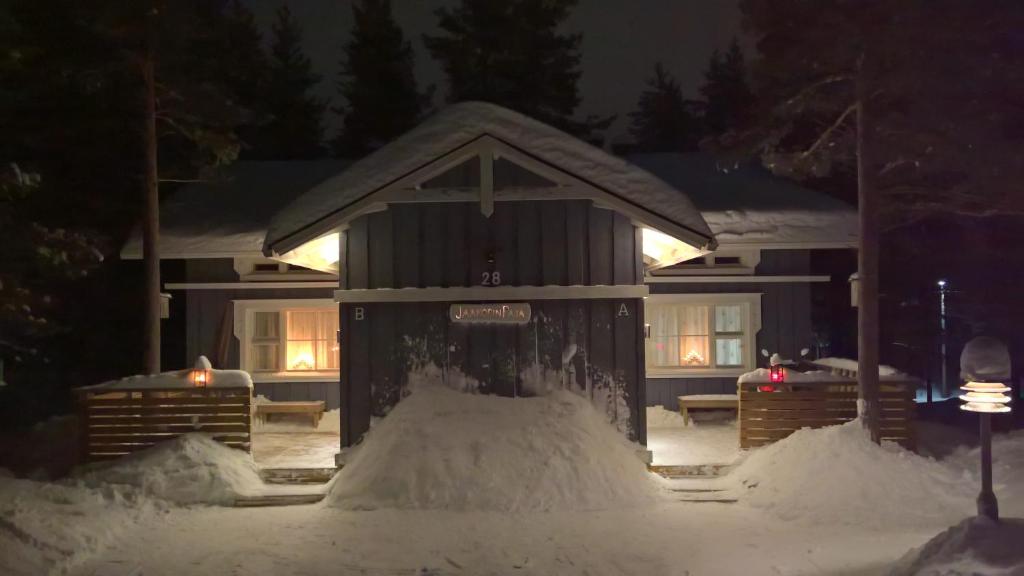 een huis met een berg sneeuw ervoor bij JaakopinPaja A&B in Levi